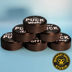 Black hockey puck fidget clicker with white text